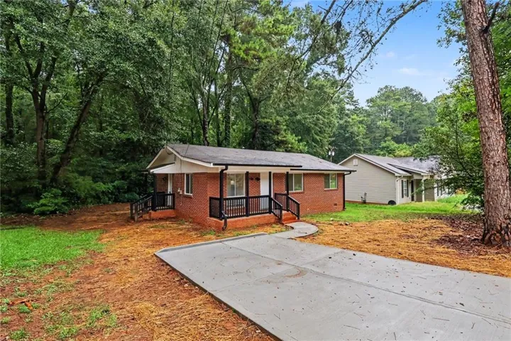 Brick ranch home set on a wooded lot with mature trees providing natural privacy