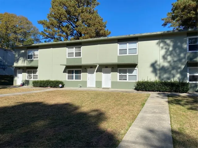 Two-story exterior with light green and dark green paneling