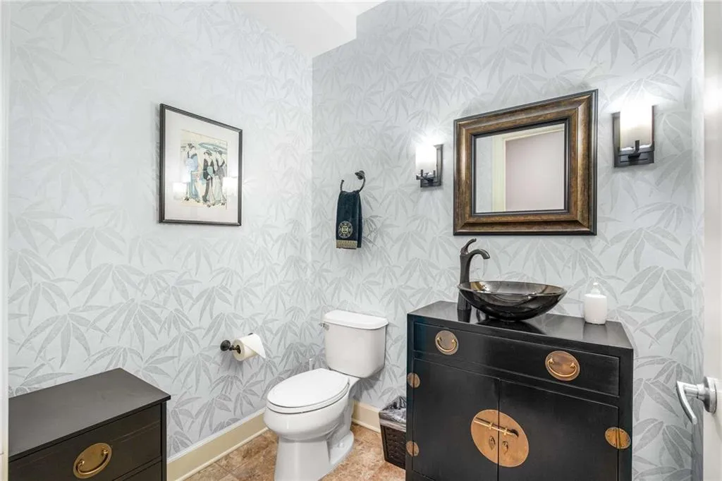 Beautiful half bath featuring vanity and wallpapered walls