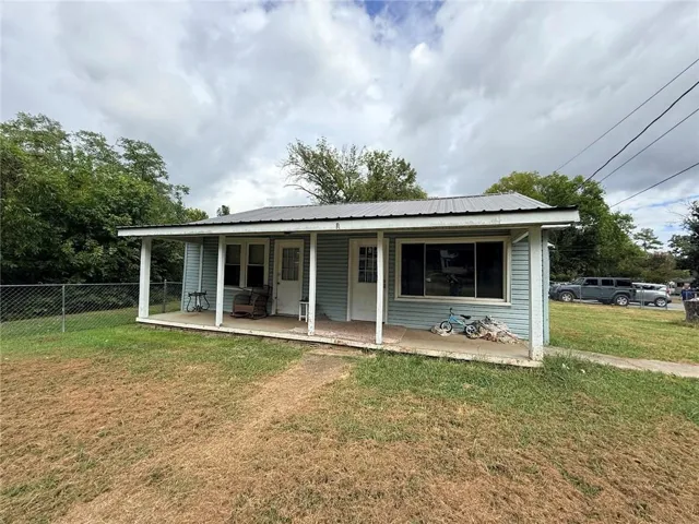 Light blue siding exterior with a dark metal roof