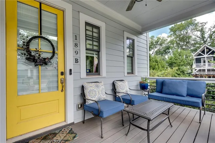 Welcoming porch with a yellow paneled door, gray siding, and an overhead ceiling fan