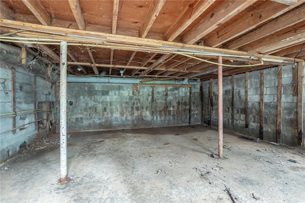 Unfinished below grade area featuring concrete block wall
