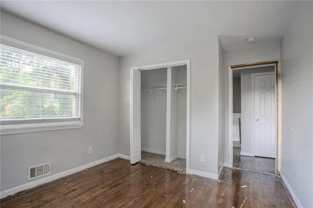 Unfurnished bedroom featuring wood finished floors and a closet