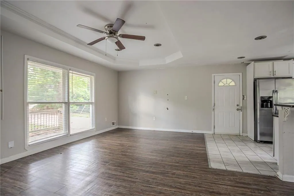 Unfurnished room with a tray ceiling, a ceiling fan, wood finished floors, and recessed lighting