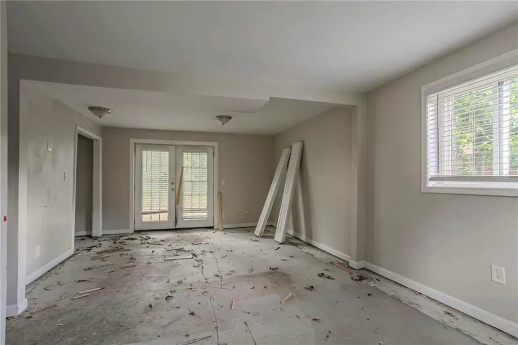 Empty room featuring baseboards and french doors