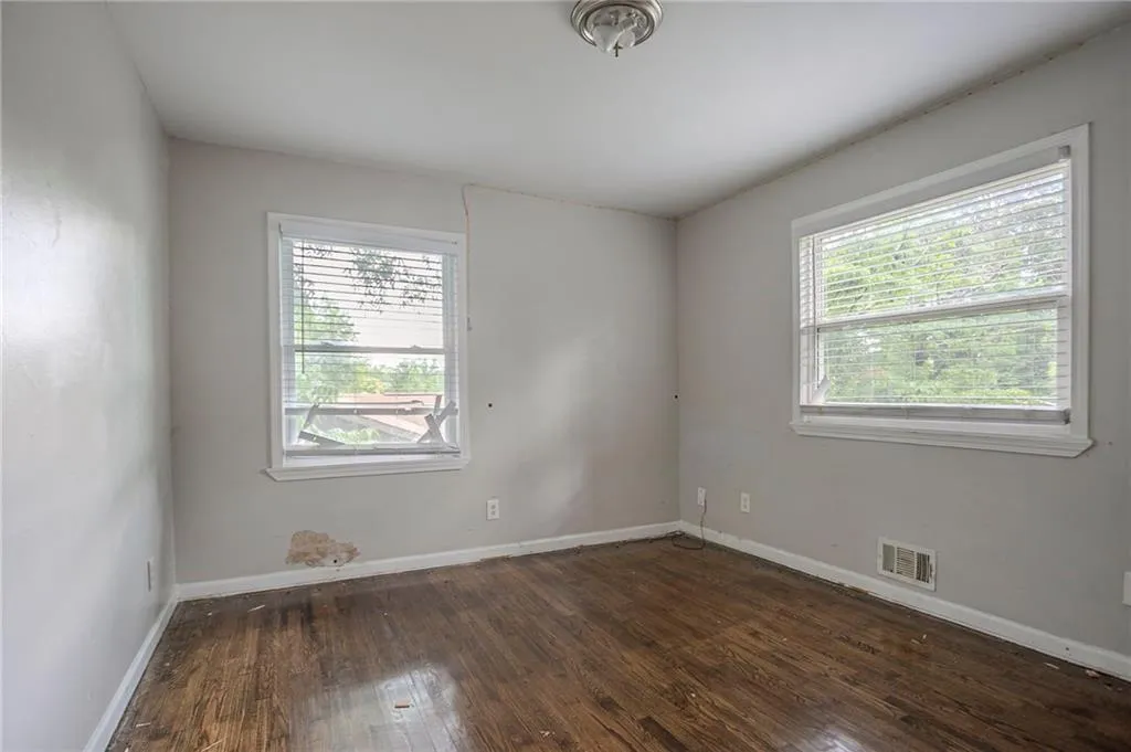 Spare room featuring wood-type flooring and baseboards
