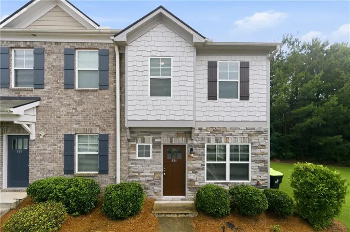 Two-story facade with stone veneer, shake siding, and brick accents