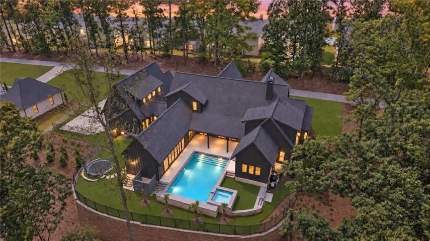Expansive property featuring a multi-gabled roofline, a large swimming pool, and an integrated spa
