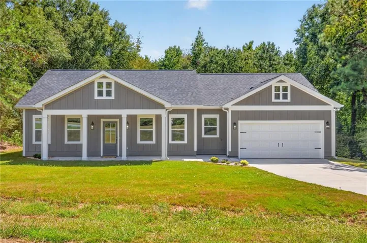 Gable roofline, gray vertical siding, white trim, covered front porch, and an attached two-car garage