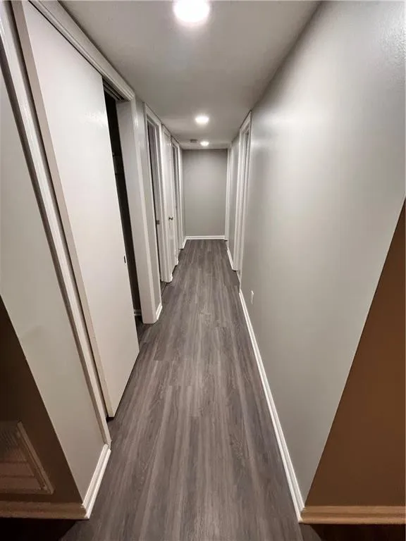 Hallway with dark wood-type flooring