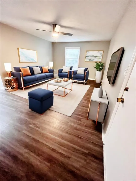 Living room featuring ceiling fan and dark -Vwood-type flooring -Virtual Staging