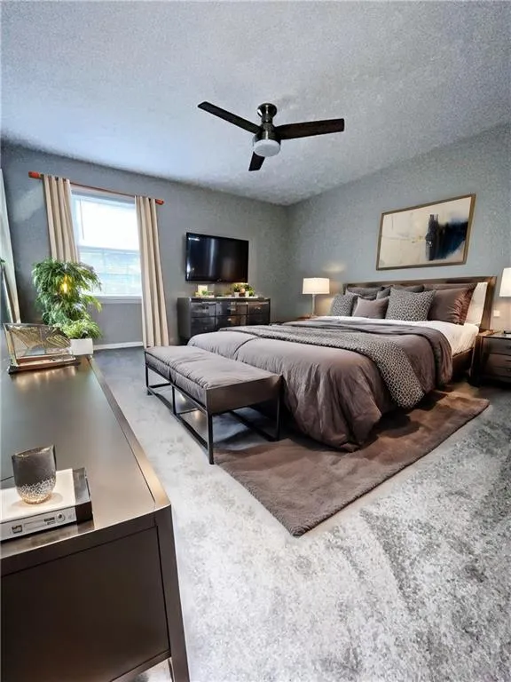 Carpeted bedroom featuring a textured ceiling and ceiling fan - Virtual Staging