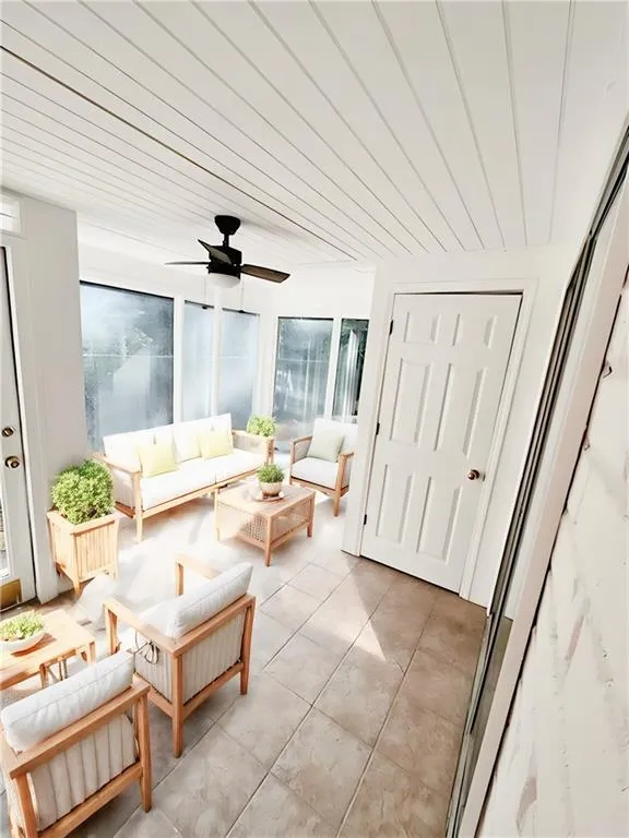 Sunroom featuring ceiling fan and wood ceiling