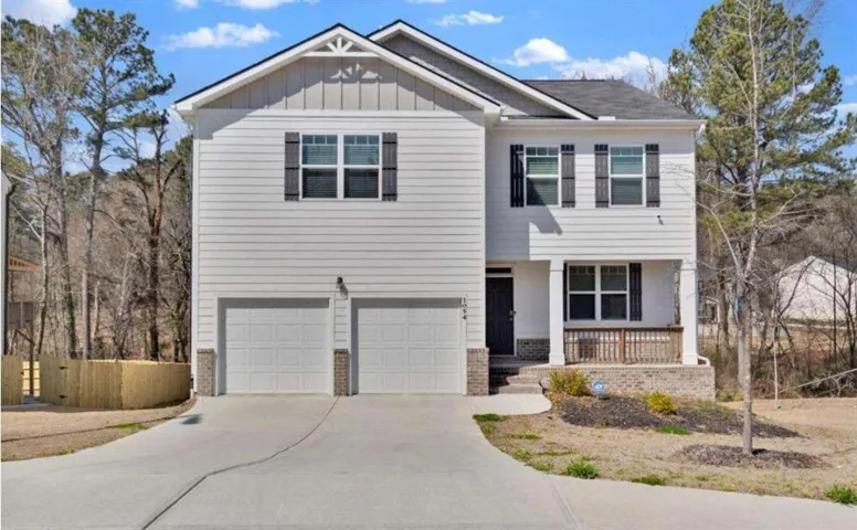 Two-story residence featuring light-colored siding and a covered front porch