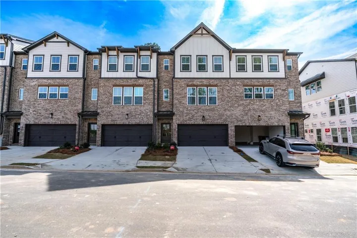 Modern townhome exterior featuring a brick and white siding facade