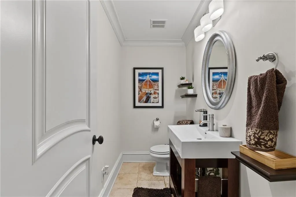 Bathroom with crown molding, vanity, and light tile patterned floors