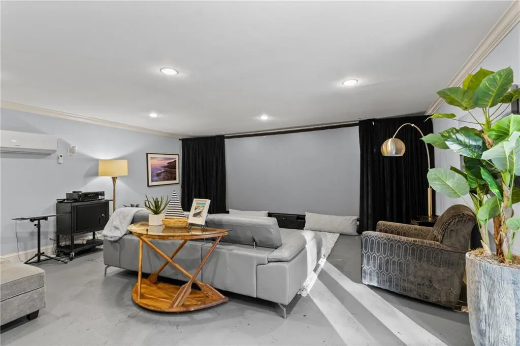 Cinema featuring concrete flooring, crown molding, recessed lighting, and a wall mounted AC