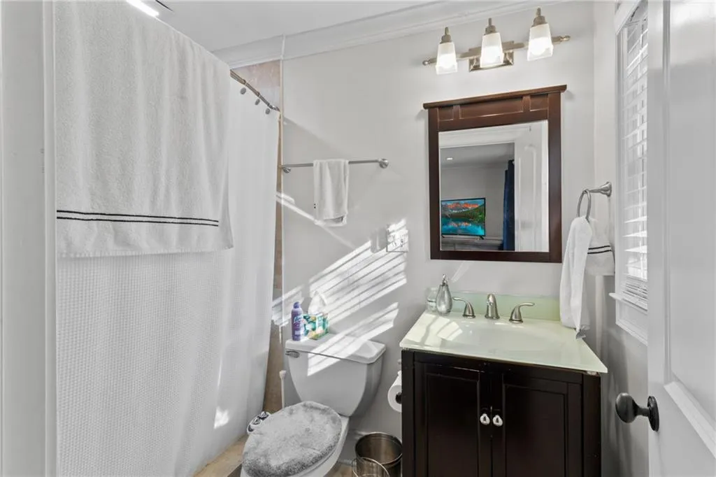 Bathroom featuring a shower with shower curtain and vanity