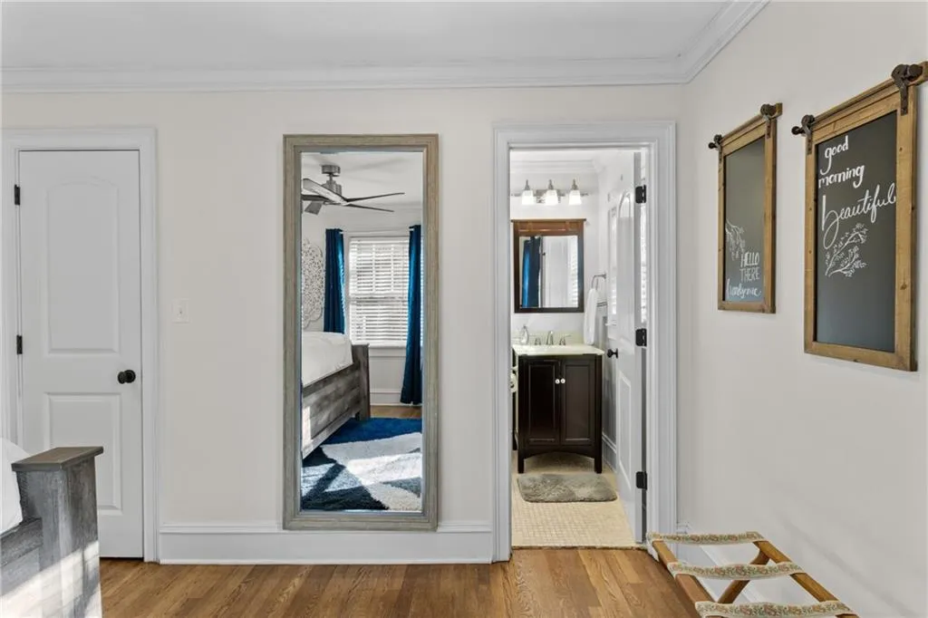 Corridor featuring light wood-type flooring and crown molding