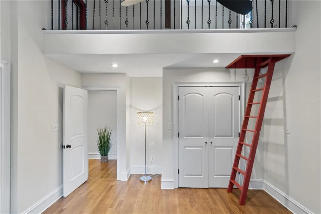 Unfurnished bedroom with light wood finished floors, a high ceiling, and recessed lighting