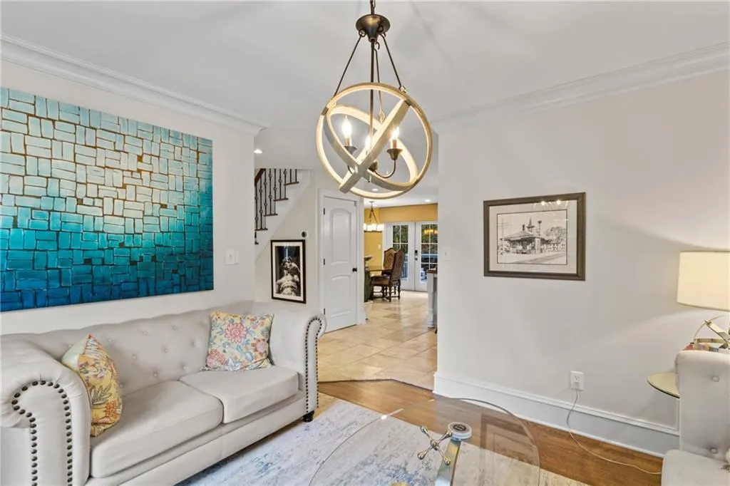 Living room featuring wood finished floors, crown molding, stairway, a chandelier, and recessed lighting