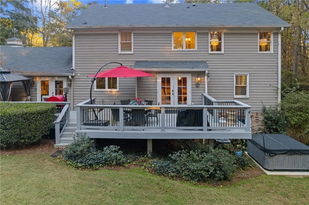 Back of house featuring a wooden deck and a lawn