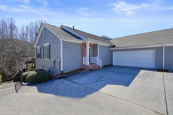 Ranch-style house with a shingled roof, driveway, and an attached garage