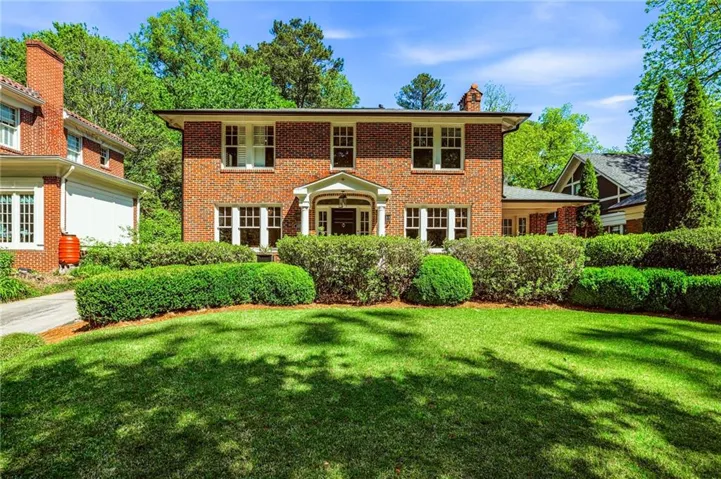 Brick exterior with a prominent front entry, featuring a gabled portico and white columns