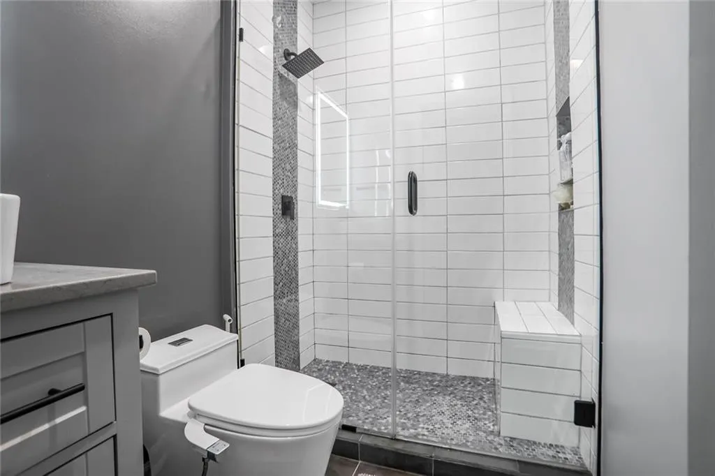 Full bathroom with a shower stall, toilet, and vanity