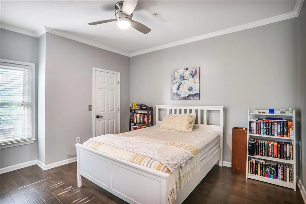 Bedroom with ornamental molding, dark wood-style floors, baseboards, and ceiling fan