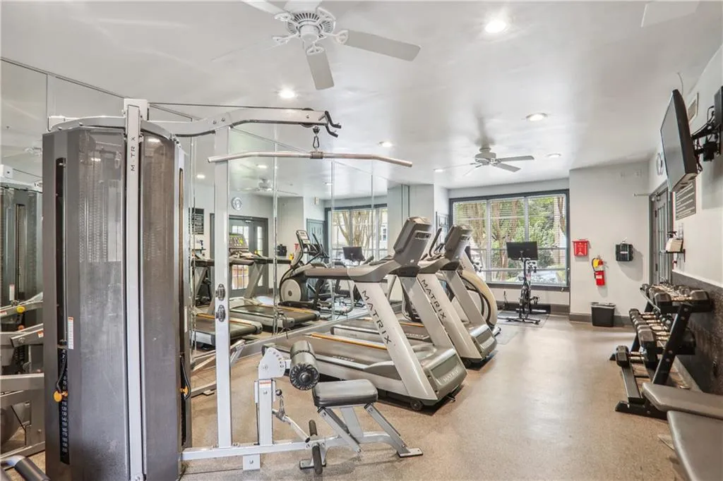 Exercise room with a ceiling fan, recessed lighting, and baseboards