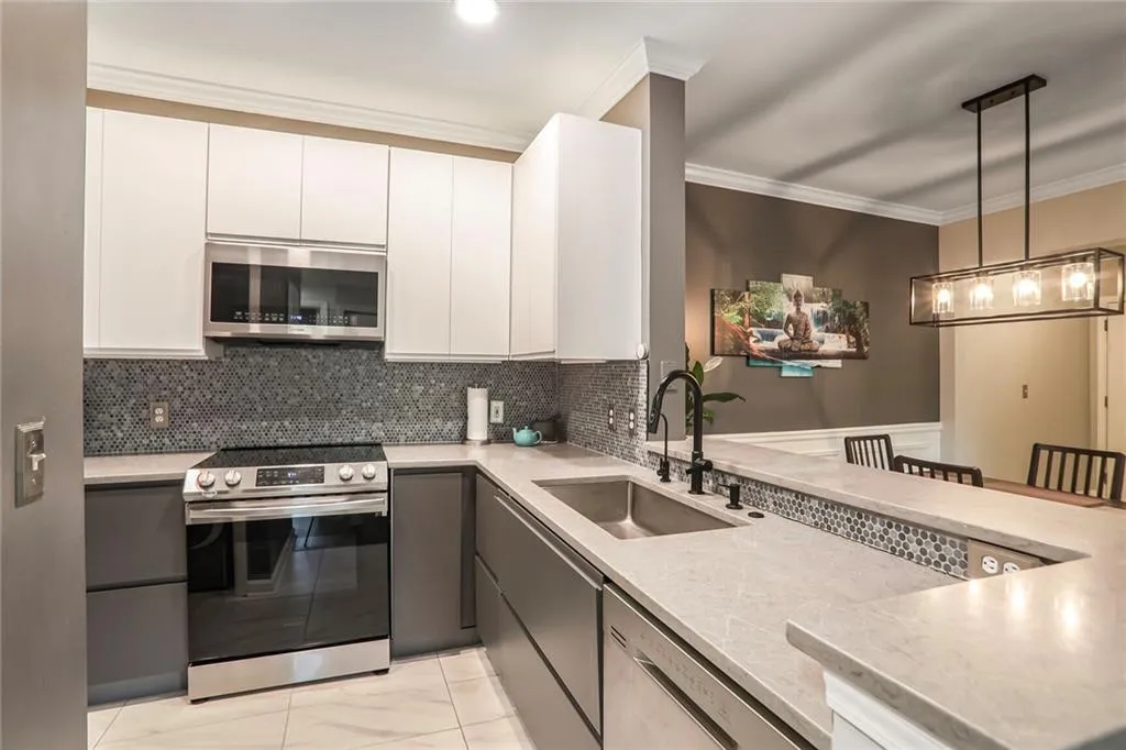 Kitchen featuring stainless steel appliances, a sink, light countertops, crown molding, and tasteful backsplash