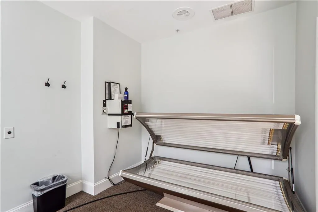 Miscellaneous room featuring carpet floors, baseboards, and a tanning bed