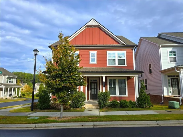 Two-story residence with red siding, white trim, and a covered front porch