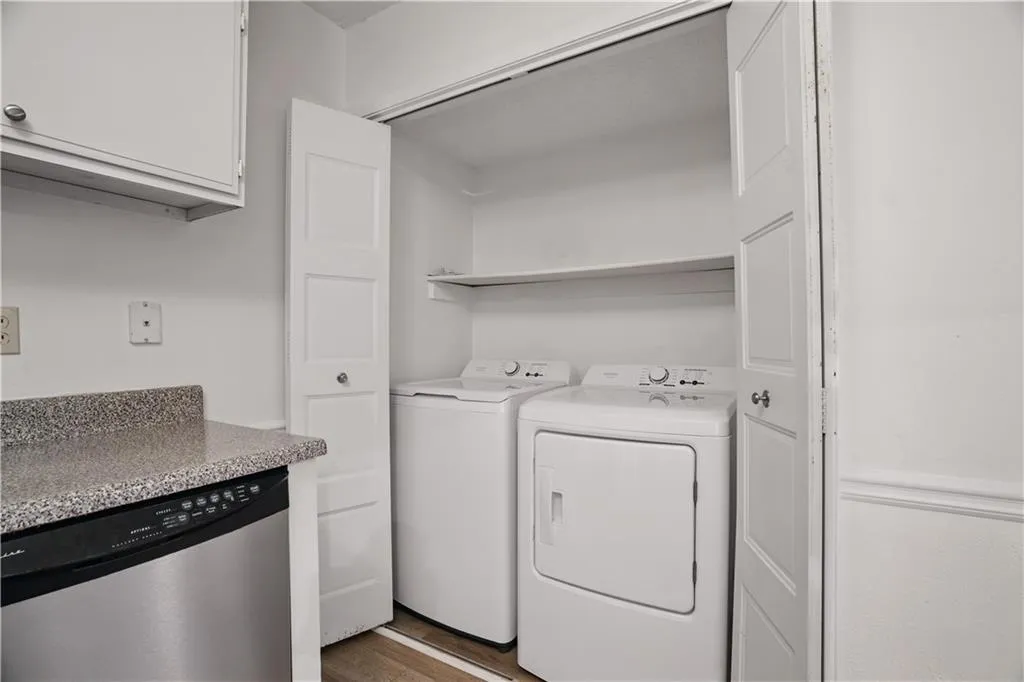 Washroom featuring wood finished floors and washer and clothes dryer