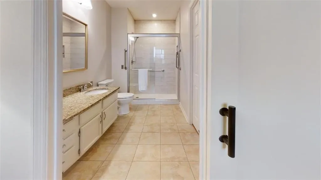 Full bathroom featuring vanity, a stall shower, light tile patterned flooring, and recessed lighting
