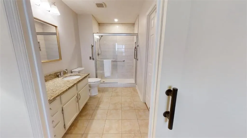 Full bathroom featuring vanity, a stall shower, recessed lighting, and light tile patterned floors