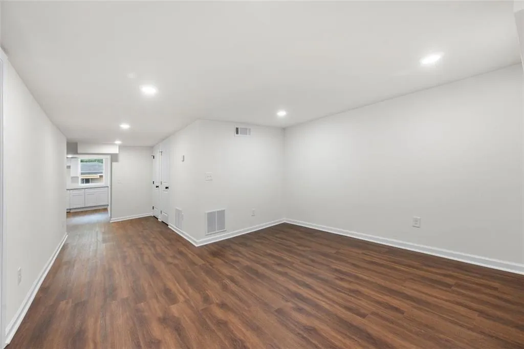 Empty room featuring dark wood finished floors and recessed lighting