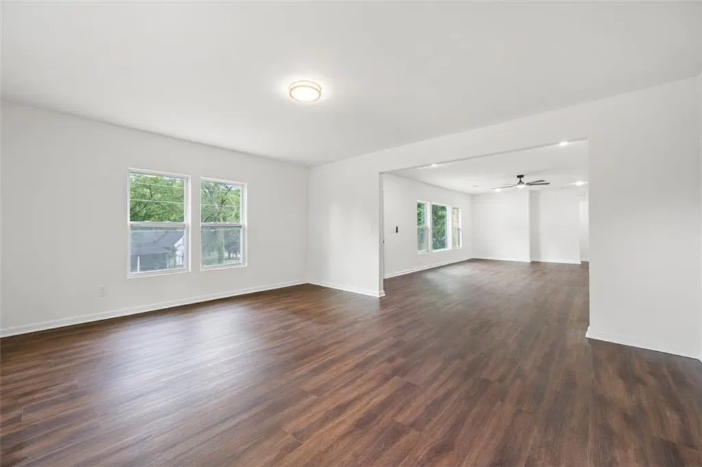 Unfurnished room with dark wood-style floors and ceiling fan