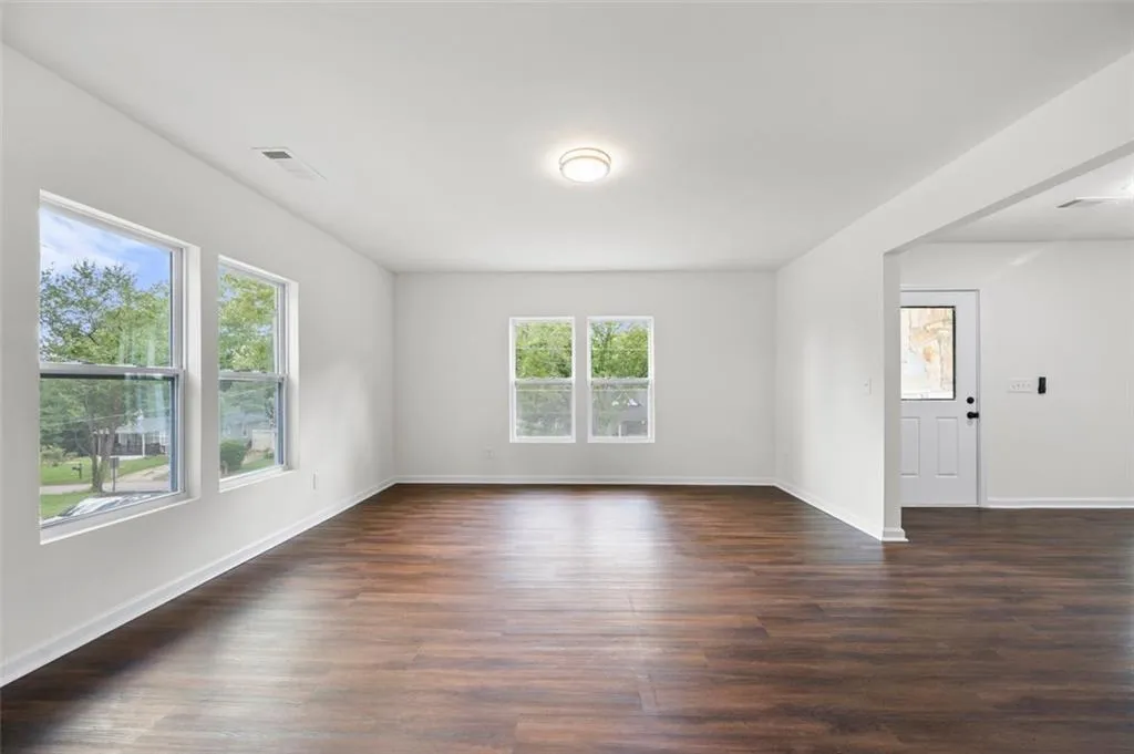 Empty room with dark wood-style flooring
