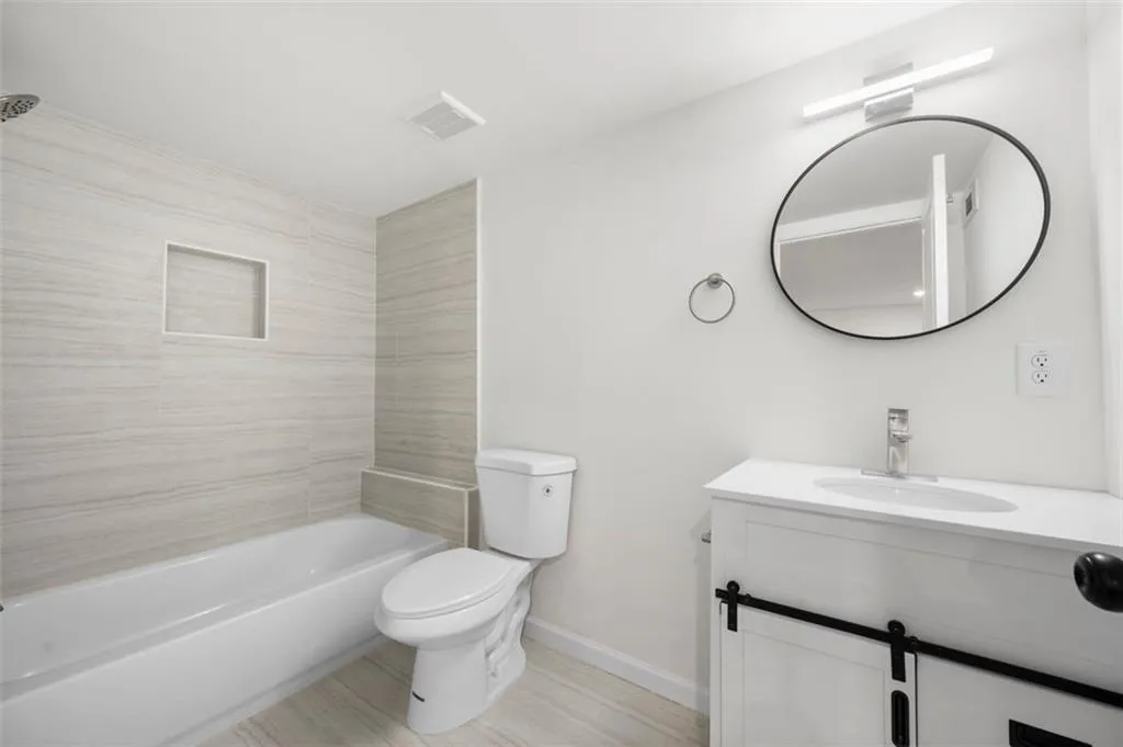 Bathroom featuring vanity and washtub / shower combination