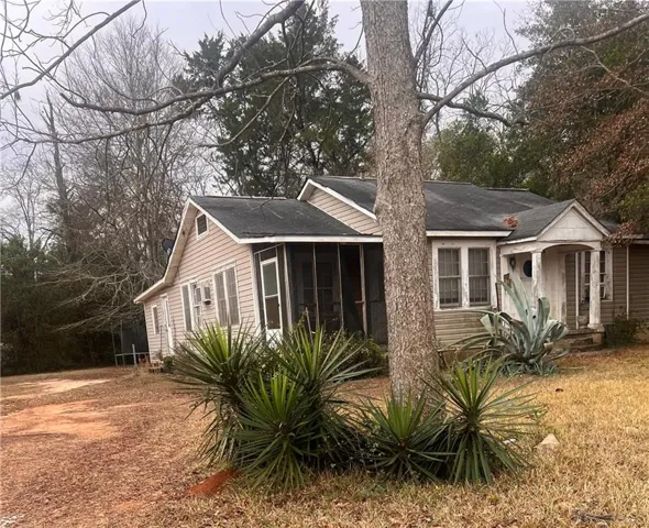 View of home's exterior with a sunroom and roof with shingles