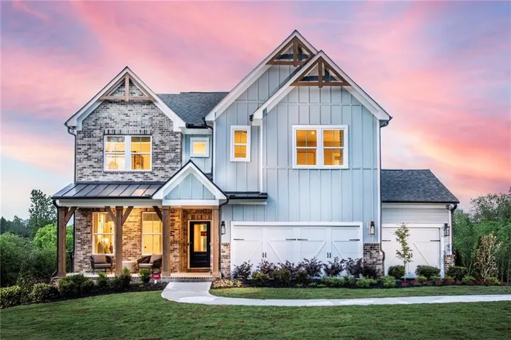 View of front of home featuring board and batten siding, a front yard, a porch, and brick siding