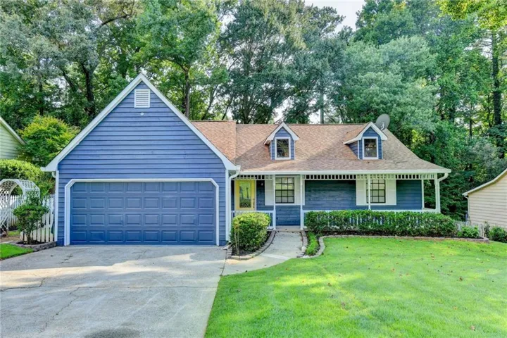 Blue siding exterior with white trim, a gabled roofline, and an attached two-car garage