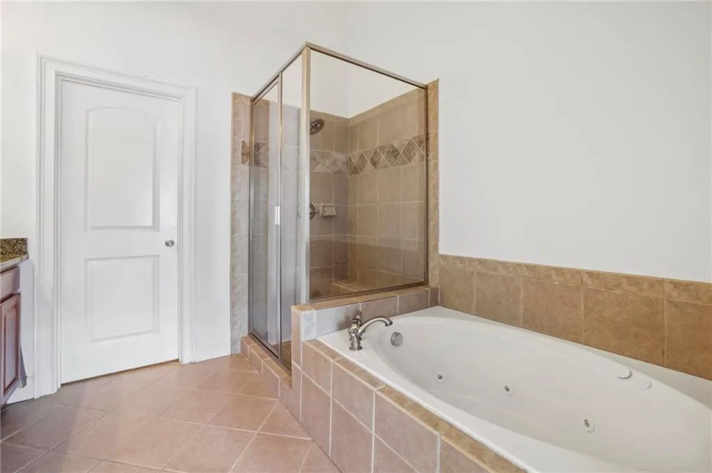 Primary Bathroom with double vanity, standing shower and a tub