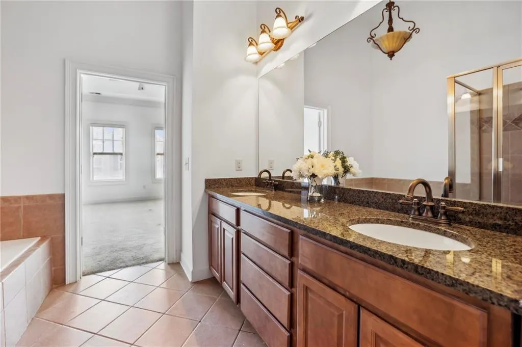 Primary Bathroom with double vanity, standing shower and a tub