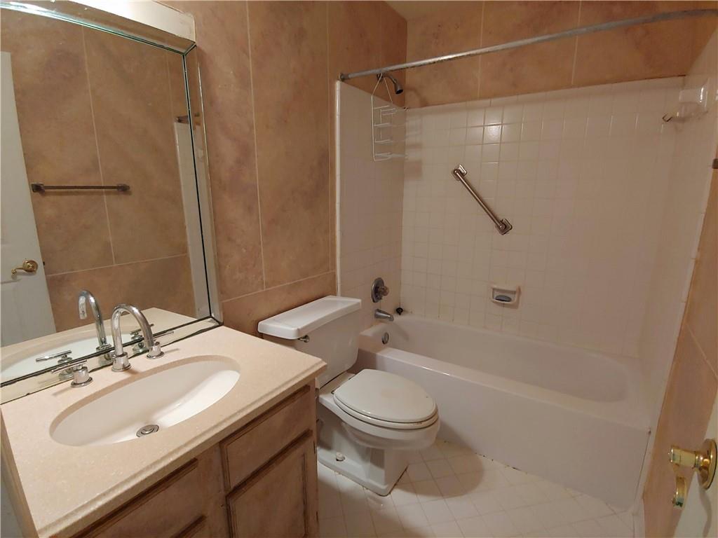Full bathroom with large vanity, tiled shower / bath, and tile floors Full bathroom with large vanity, tiled shower / bath, and tile floors