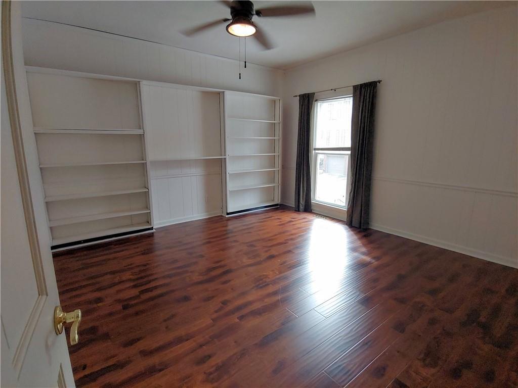 Library or office with book shelves, dark hardwood flooring and ceiling fan Library or office with book shelves, dark hardwood flooring and ceiling fan