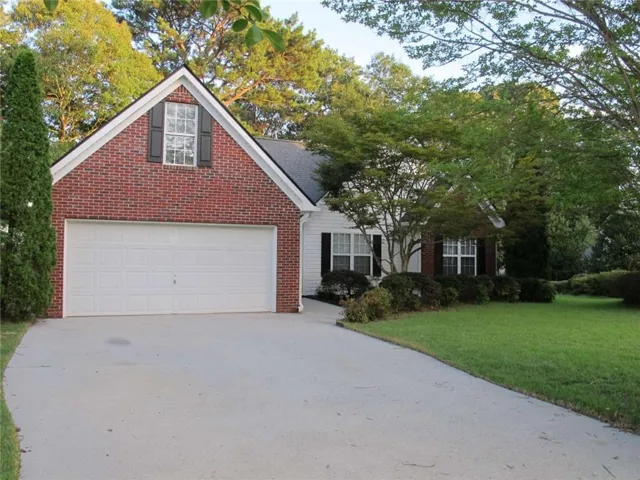 Exterior featuring a brick and siding facade with a two-car garage and a concrete driveway