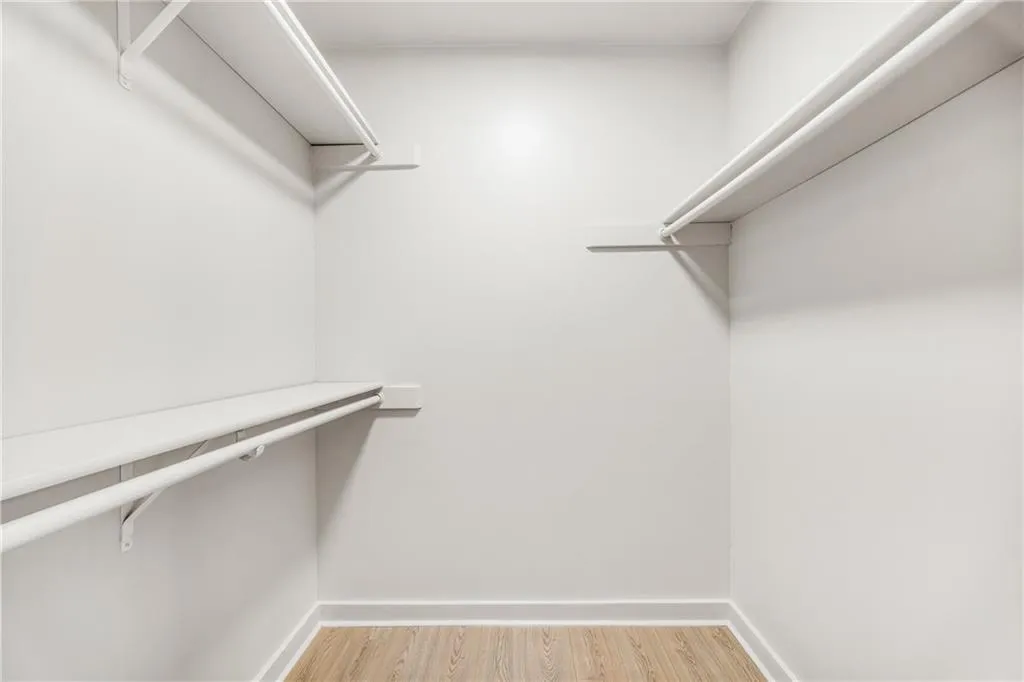 Walk in closet with light wood-style flooring
